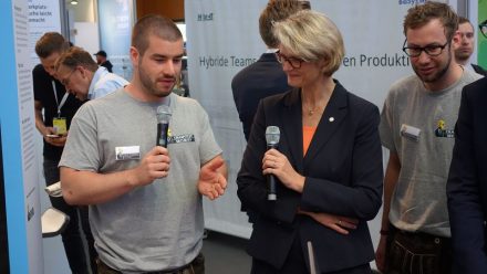 Felix Brombacher (li.) von Crashtest Security erklärt Ministerin Karliczek, was sein Startup leistet.