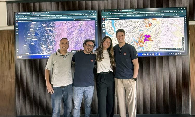 Ororatech VertreterInnen und lokale Partner posieren vor Live Dashboards zur Waldbrandüberwachung im Überwachungszentrum von Río Negro